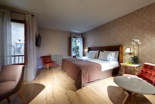 塞哥维亚埃克卡萨德洛斯丽娜杰酒店的卧室配有1张床、1张桌子和1把椅子