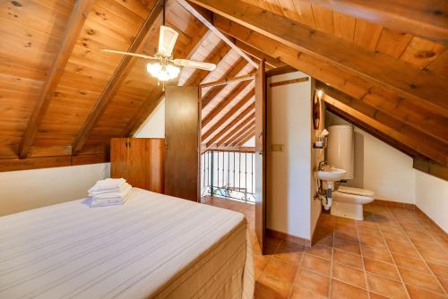 奥亨Casa rural entre Ojén y Marbella的一间带一张床的卧室,位于带木制天花板的房间内