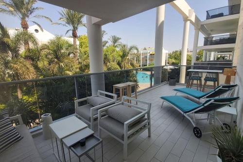 埃拉特Garden and Pool at Royal Park Eilat的房屋内的阳台配有桌椅