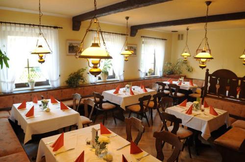 ReichenbachBeierleins Hotel & Catering GMBH的餐厅设有白色的桌椅和窗户。