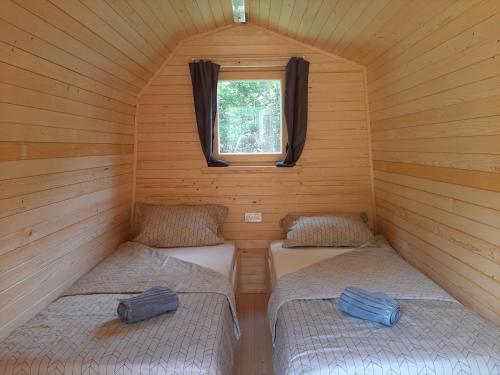 普雷德沃尔Camping & Glamping Grintovec的小屋内带两张床的小房间