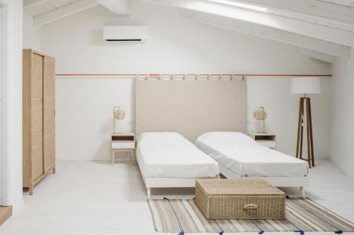 卡洛福泰AltaMarea - Ampi spazi in Centro storico的白色的客房配有两张床和一张桌子