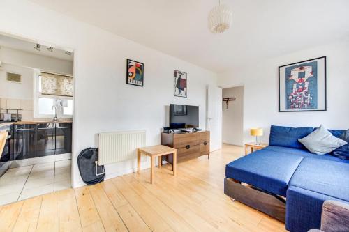 伦敦GuestReady - Penthouse Flat in Trendy Peckham的一间带蓝色床的卧室和一间厨房