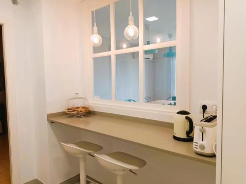 埃勒凡达尔Villa Service - Coral III的厨房配有带2张凳子和镜子的台面