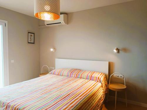 埃勒凡达尔Villa Service - Coral III的一间卧室配有一张带条纹床罩的床