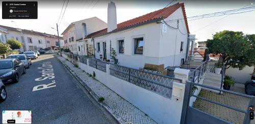 科英布拉Cantinho da Susana的街道上设有白色房屋和汽车的街道