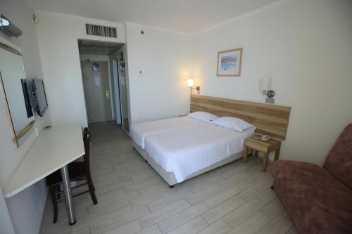 埃拉特阿迪酒店 的卧室配有白色的床和书桌