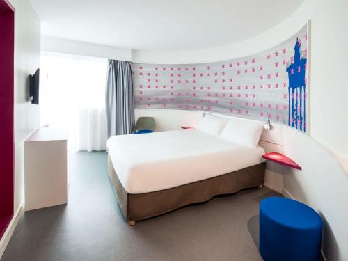 旺德尔港科利尤尔旺德尔港宜必思尚品酒店的卧室配有白色的床和红色的墙壁