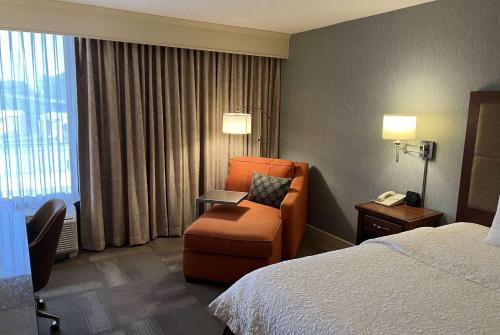 圣安Wingate by Wyndham St Louis Airport的酒店的客房 - 带一张床、椅子和窗户