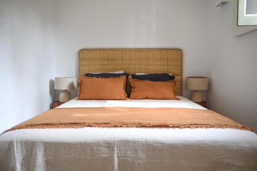 阿加尼尔Vumba Agroturismo的一间卧室配有一张带橙色枕头的大床