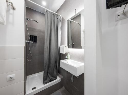 巴塞罗那巴塞罗那中心无限旅舍的白色的浴室设有水槽和淋浴。