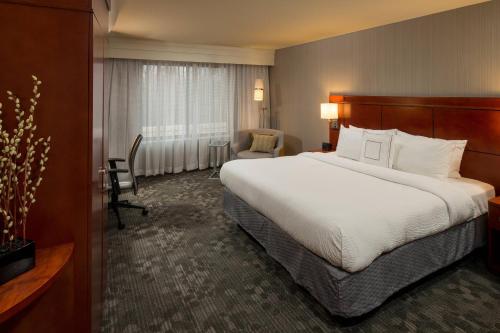 拉法叶拉斐特万怡酒店的酒店客房带一张大床和一把椅子