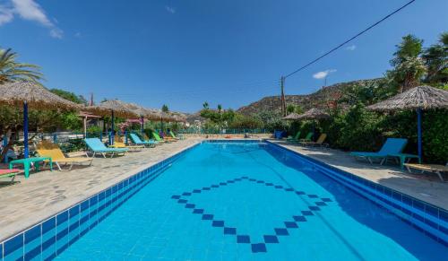 马塔拉马塔拉珊瑚酒店的度假村的游泳池配有椅子和遮阳伞