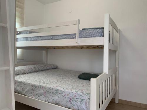 甘迪亚海滩Bonito y coqueto apartamento a 150metros de la playa 2 Línea的一间带两张双层床的卧室和楼梯
