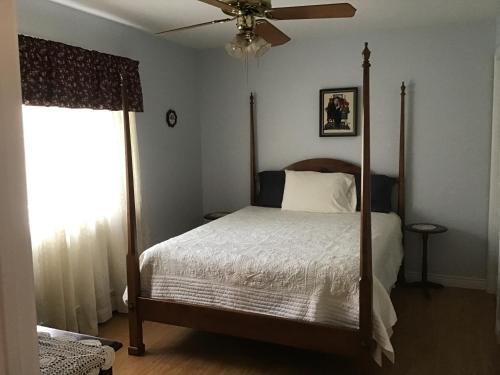 萨默赛德Guest Suites at Willowgreen Farm的一间卧室配有一张床和吊扇