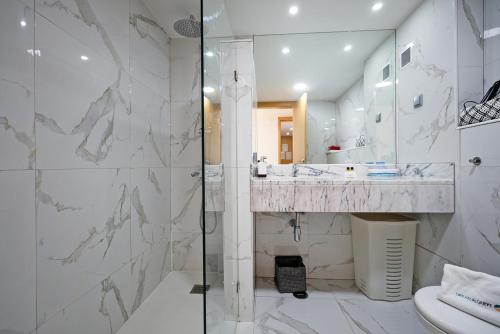 拉戈斯B19 - Marina Bay Apartment的带淋浴、盥洗盆和卫生间的浴室