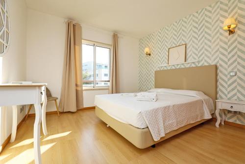 拉戈斯B19 - Marina Bay Apartment的一间卧室配有一张床、一张书桌和一个窗户。