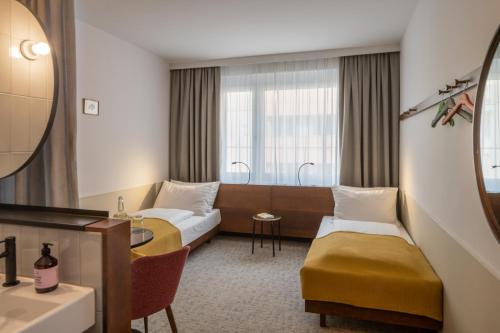 维也纳magdas HOTEL Vienna City - First Social Business HOTEL in Austria的酒店客房设有两张床和一张桌子。