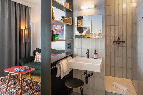 维也纳magdas HOTEL Vienna City - First Social Business HOTEL in Austria的一间带水槽和椅子的小浴室