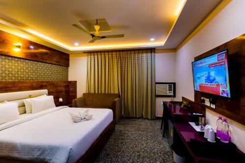 普里Xenious Hermitage Koshal, Puri的配有一张床和一台平面电视的酒店客房