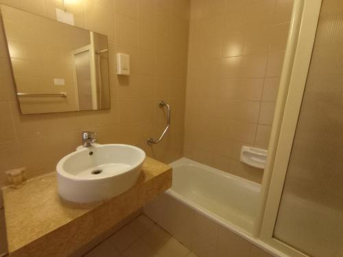 圣保罗湾城圣安东公寓式酒店的浴室配有盥洗盆和浴缸。