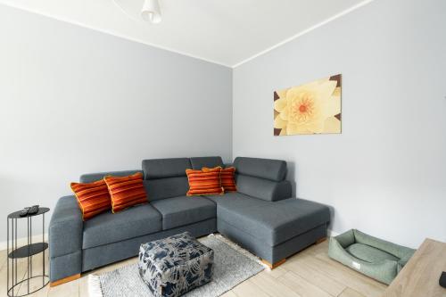 波兹南Apartment with garden Wolkowyska by Renters的客厅配有蓝色沙发和橙色枕头。