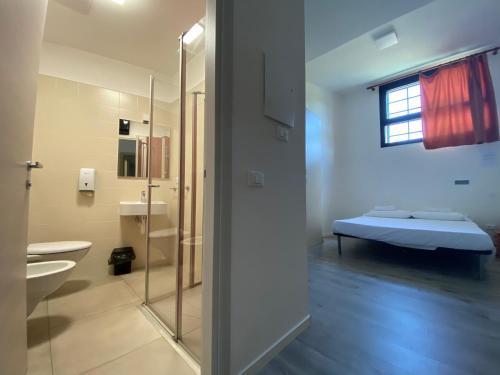 维琴察维琴察欧斯特罗迪酒店的浴室设有床铺和玻璃淋浴间。