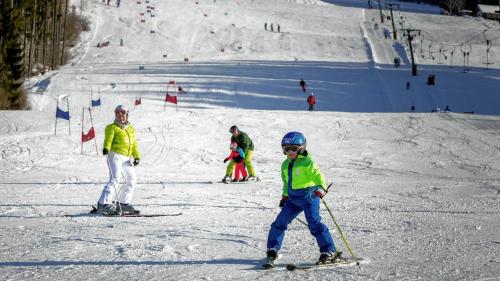 Almzeithütte am Seeberg的一群人沿着雪覆盖的斜坡滑雪