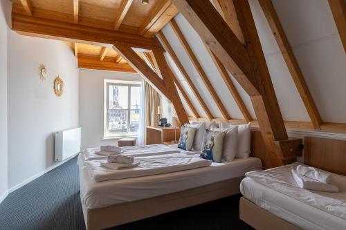 弗利辛恩Hotel Stad aan Zee Vlissingen的配有木天花板的客房设有两张床。