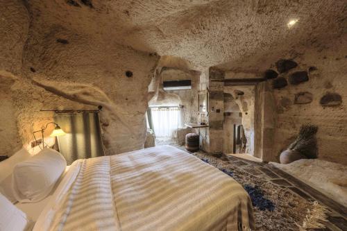 格雷梅Kelebek Special Cave Hotel & Spa的石屋设有一间带大床的卧室