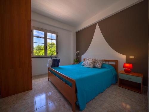 里卡迪Residence Olimpo的一间卧室设有蓝色的床和窗户。