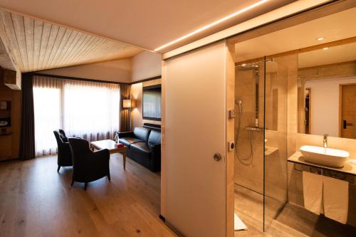 沙尔梅Hôtel Cailler & Bains de la Gruyère的客房内设有带水槽和淋浴的浴室