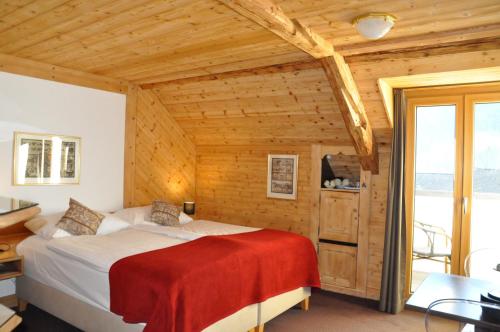 沙尔梅Résidence le Sapin & Bains de la Gruyère的木制客房内的一间卧室,配有一张床