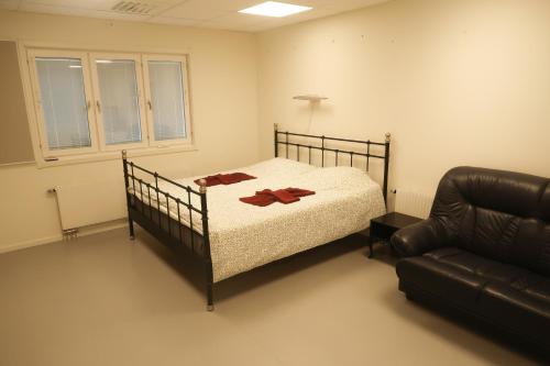 SlädaSkrå hostel - bed & business的一间卧室配有一张床和一张皮沙发