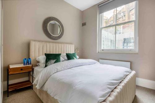 伦敦Hampstead High Flyer的一间卧室配有一张带镜子的床和窗户