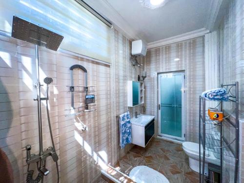 特马Golden Touch Executive Hotel的带淋浴、卫生间和盥洗盆的浴室