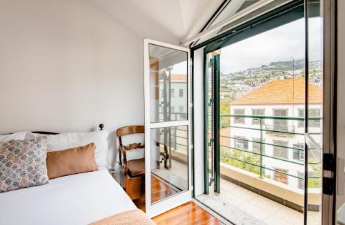 丰沙尔A ver o mar rooms- Funchal city center的一间卧室设有一张床和一个大窗户