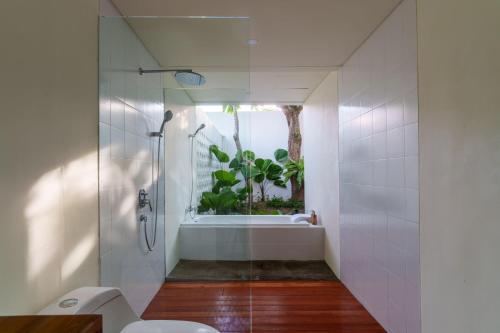 马塔兰Ayom Suite的带淋浴和卫生间的浴室以及窗户。
