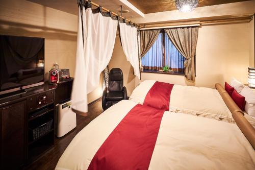 大阪Hotel Bali An Resort Nambadotonbori的酒店客房设有两张床和电视。