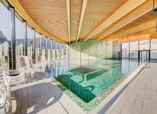 沙尔梅Résidence le Sapin & Bains de la Gruyère的铺有绿色瓷砖的室内游泳池