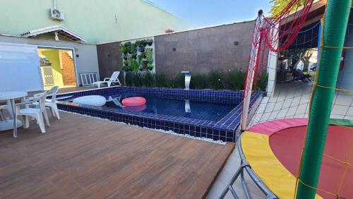 大普拉亚Pousada Vila Real PG的后院设有带桌椅的游泳池
