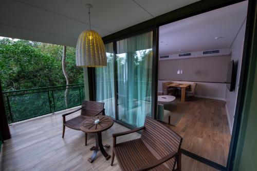 伊瓜苏港伊瓜苏丛林别墅酒店的客房设有带桌椅的阳台。