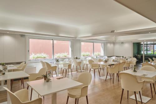 巴塞罗那特雷斯托雷斯阿迪拉姆酒店的用餐室设有桌椅和窗户。