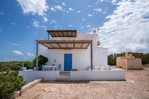 拉萨维纳Cas Saliners - Parc Natural的一间白色的小房子,设有蓝色的门
