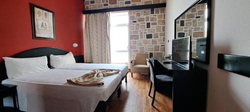 萨尔雷Hotel Dunas Ilha da Boavista Sal Rei的酒店客房配有一张床、一张书桌和一台电视。