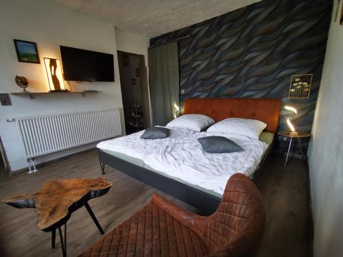 BöchingenLandhaus Messerschmitt的卧室配有1张床、1张桌子和1把椅子