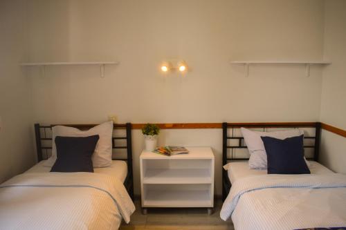 华沙艾库斯旅舍的一间卧室配有两张床,中间设有床头柜。