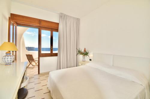 潘泰莱里亚Cossyra Hotel的白色的卧室设有床和窗户