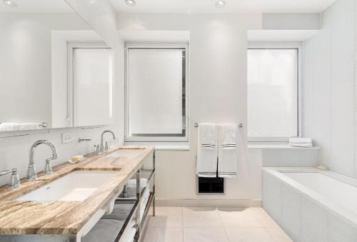 纽约Luxury Midtown West 4 Bedroom Apartment Near Radio City的白色的浴室设有2个盥洗盆和1个浴缸。