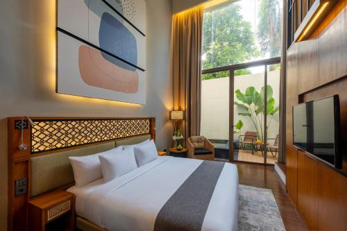 塞米亚克Kayumas Seminyak Resort的卧室设有白色的床和大窗户